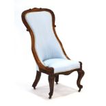 A Victorian mahogany and watered silk nursing chair on acanthus capped front legs with castors
