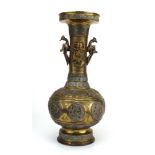 A Chinese cast brass vase of elongated form having a pair of peacock handles and a body decorated