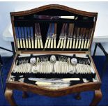 An early 20th century walnut veneer canteen containing silver flatware comprising: 4 x table spoons,