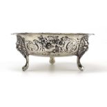 A Victorian silver bon bon dish repousse decorated with floral motifs on three masque feet,