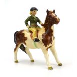 A Beswick figure modelled as a girl seated on a pony, Model No. 1499, h. 13.