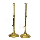 A pair of late 19th/early 20th century brass ejector-type candlesticks in the Ecclesiastical manner