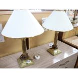 Pair of brass column shape table lamps with tapered white and gilt shades