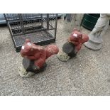 2 concrete garden ornaments of squirrels sitting on logs