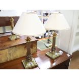 Pair of brass column shape table lamps with tapered white and gilt shades