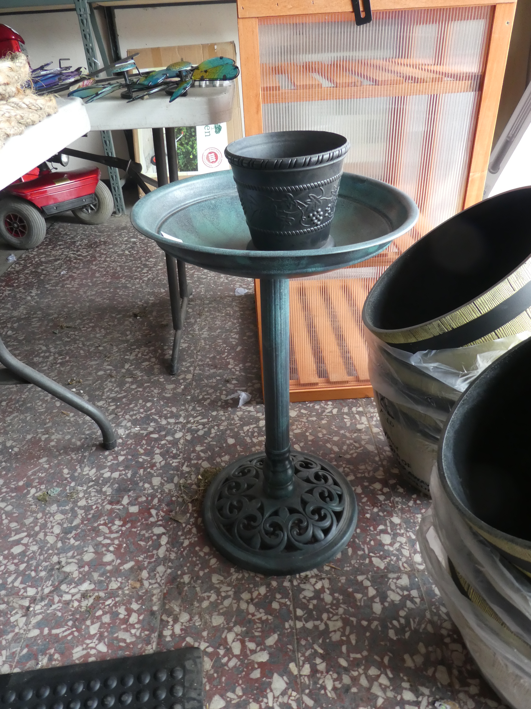 Green plastic bird table with flower pot