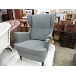 Grey upholstered wing back easy chair