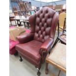 Red leather effect wing backed armchair