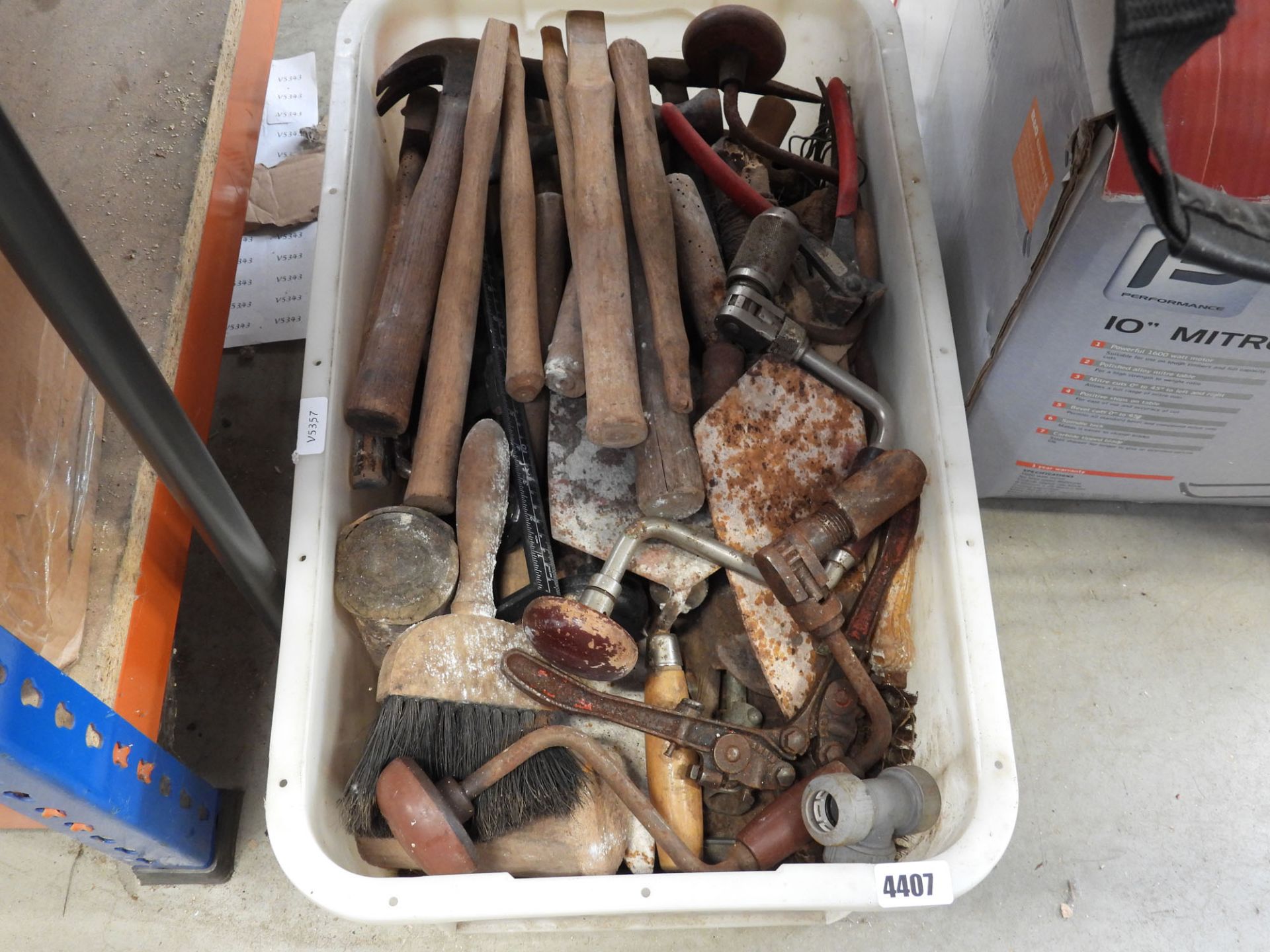 Plastic box containing hammer handles, hand drills and various other vintage tools