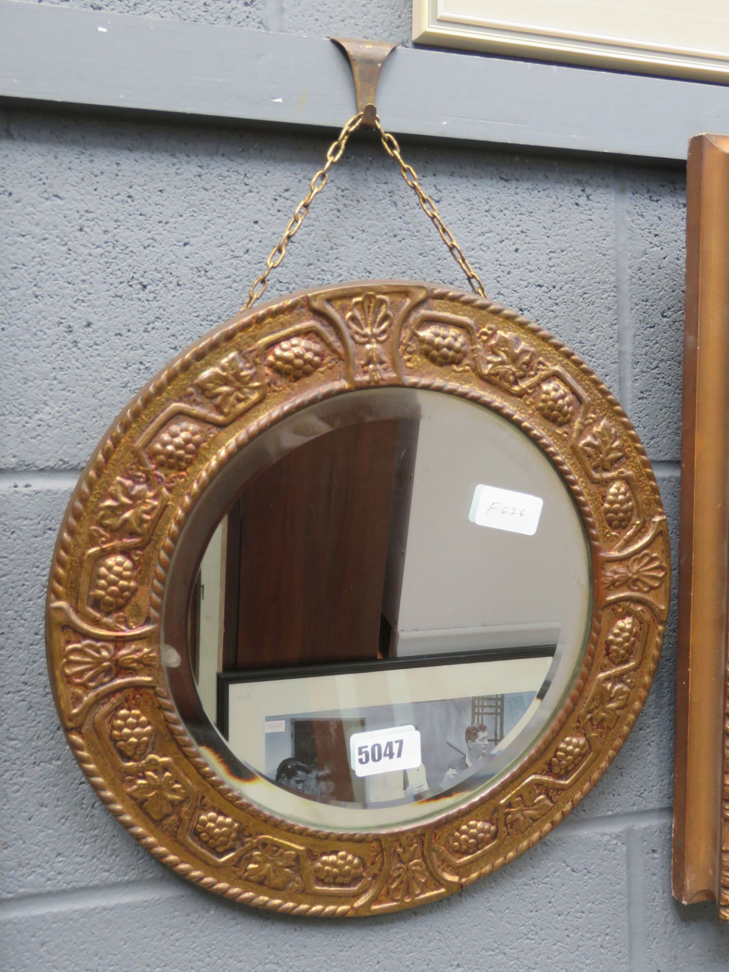 Small circular bevelled mirror in gold painted metal frame