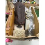 Box containing a Gladstone bag, brass belt buckles, large whiskey bottle, folding wooden rulers plus
