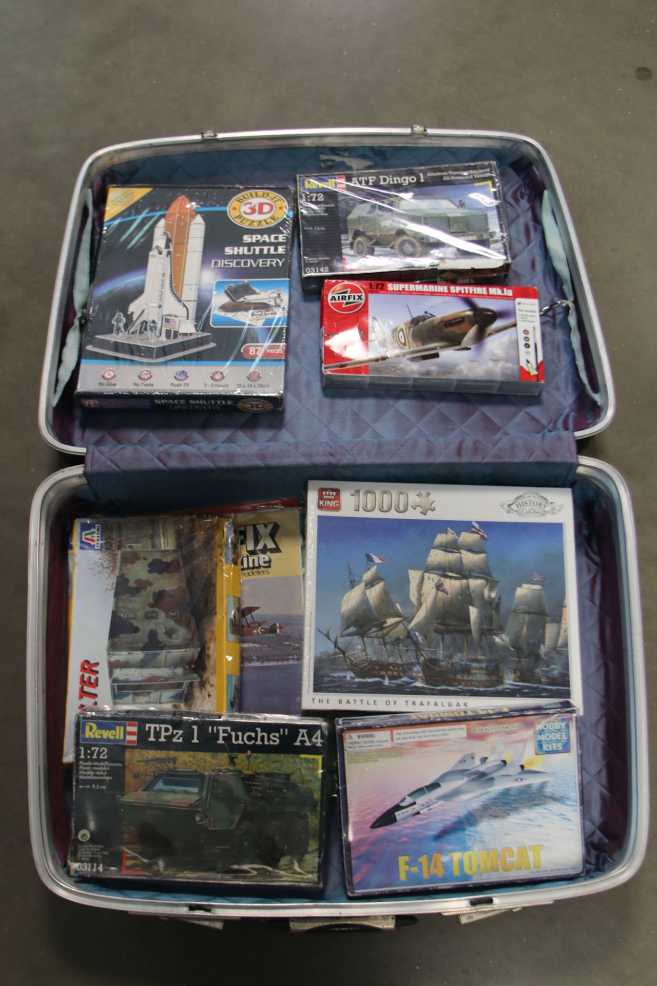 Suitcase containing various puzzles, Revell models, Airfix kits etc.
