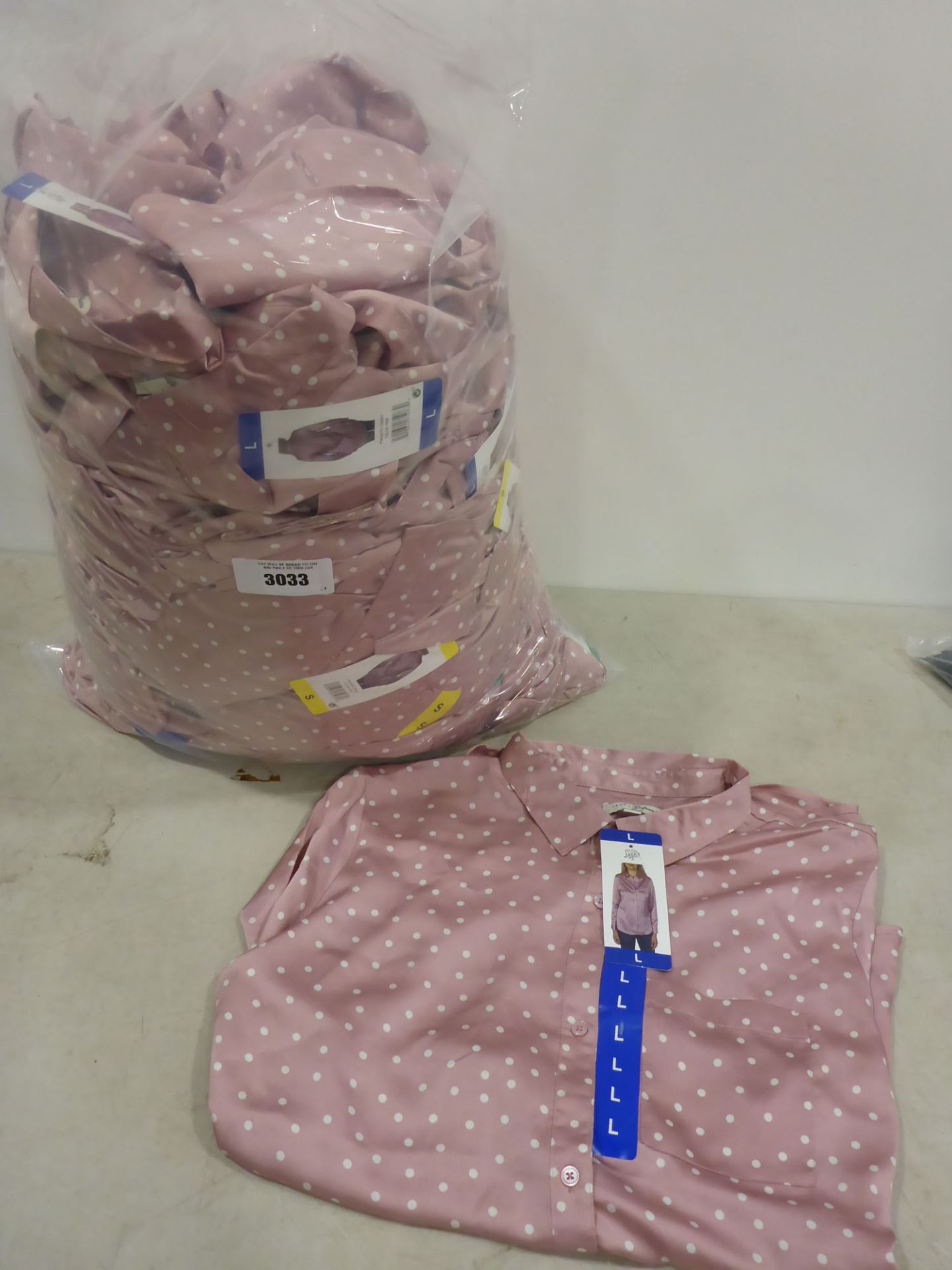 Bag containing ladies tops by Jackson New York in pink polka dots