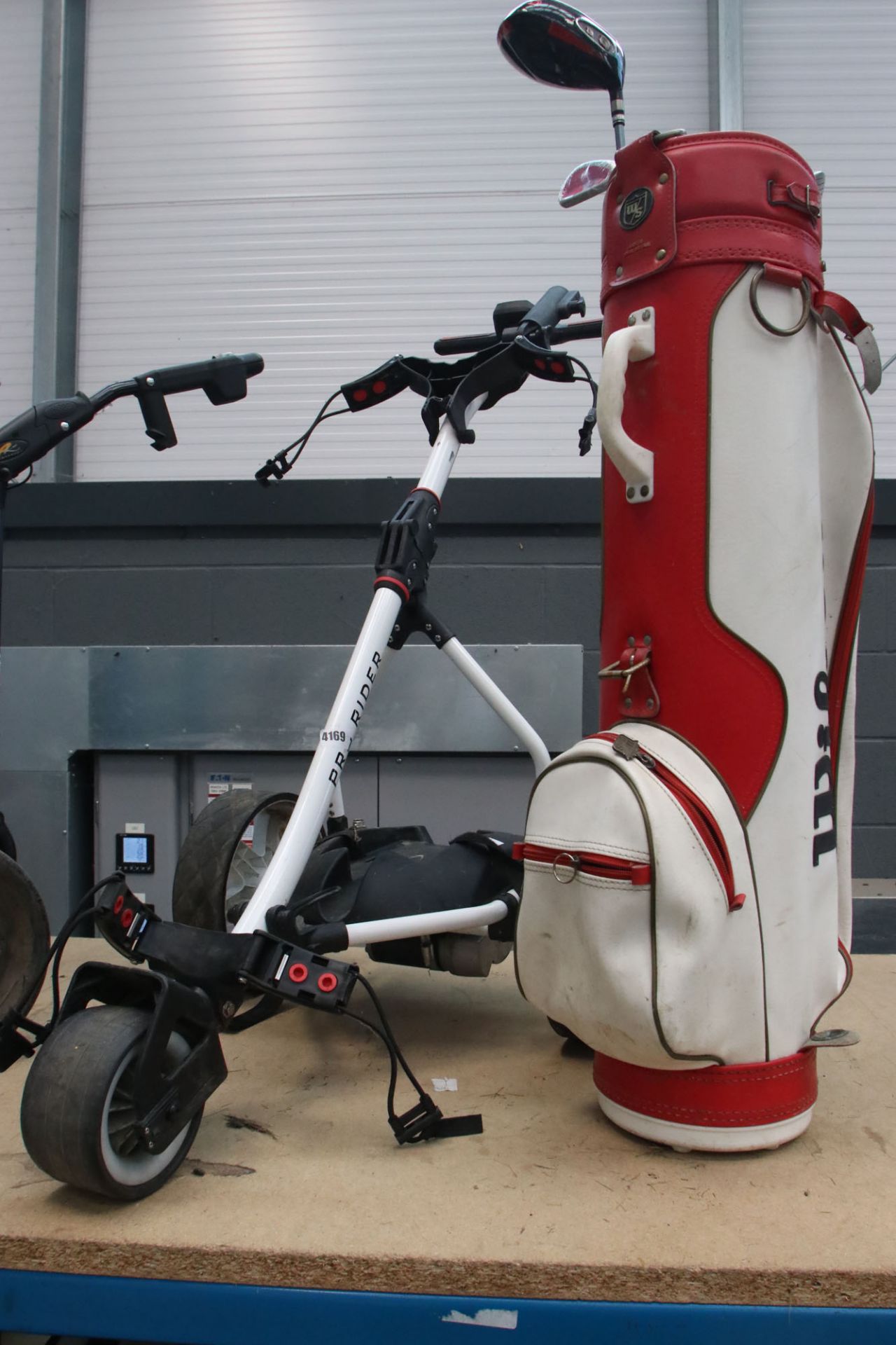 White ProRider electric golf trolley with red Wilson bag including a quantity of clubs, no