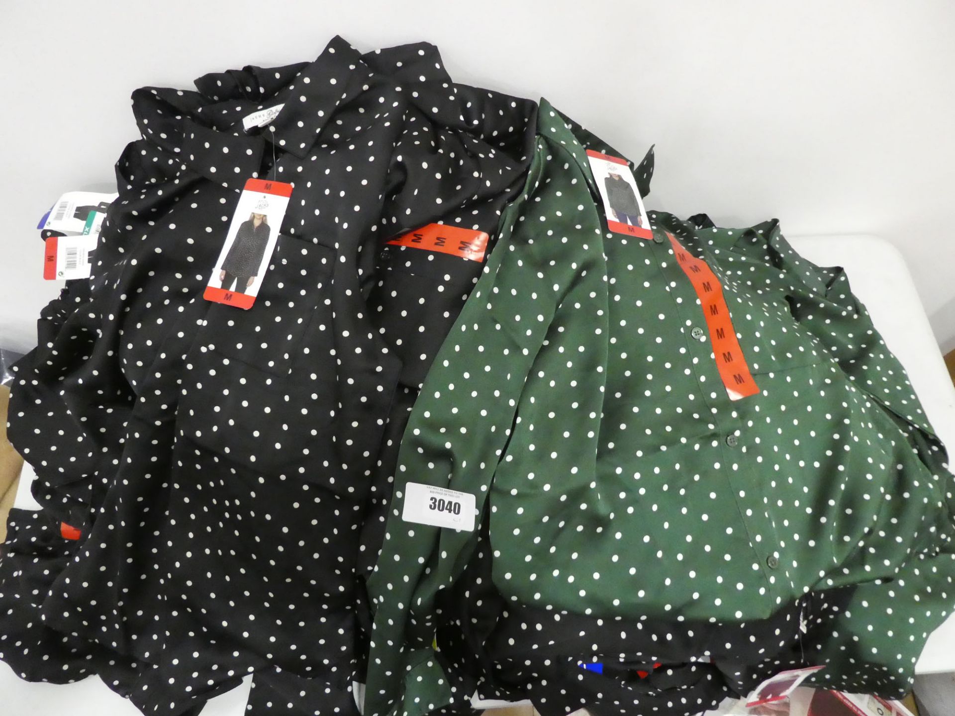 Bag containing Jachs girlfriend blouses in green with black polka dots as well as gold with black