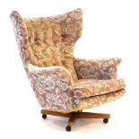 A 1960's G-Plan 6250 wingback armchair with button upholstery on a four-star base with castors *In