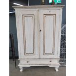Cream painted double door cupboard with sloping back and drawer under
