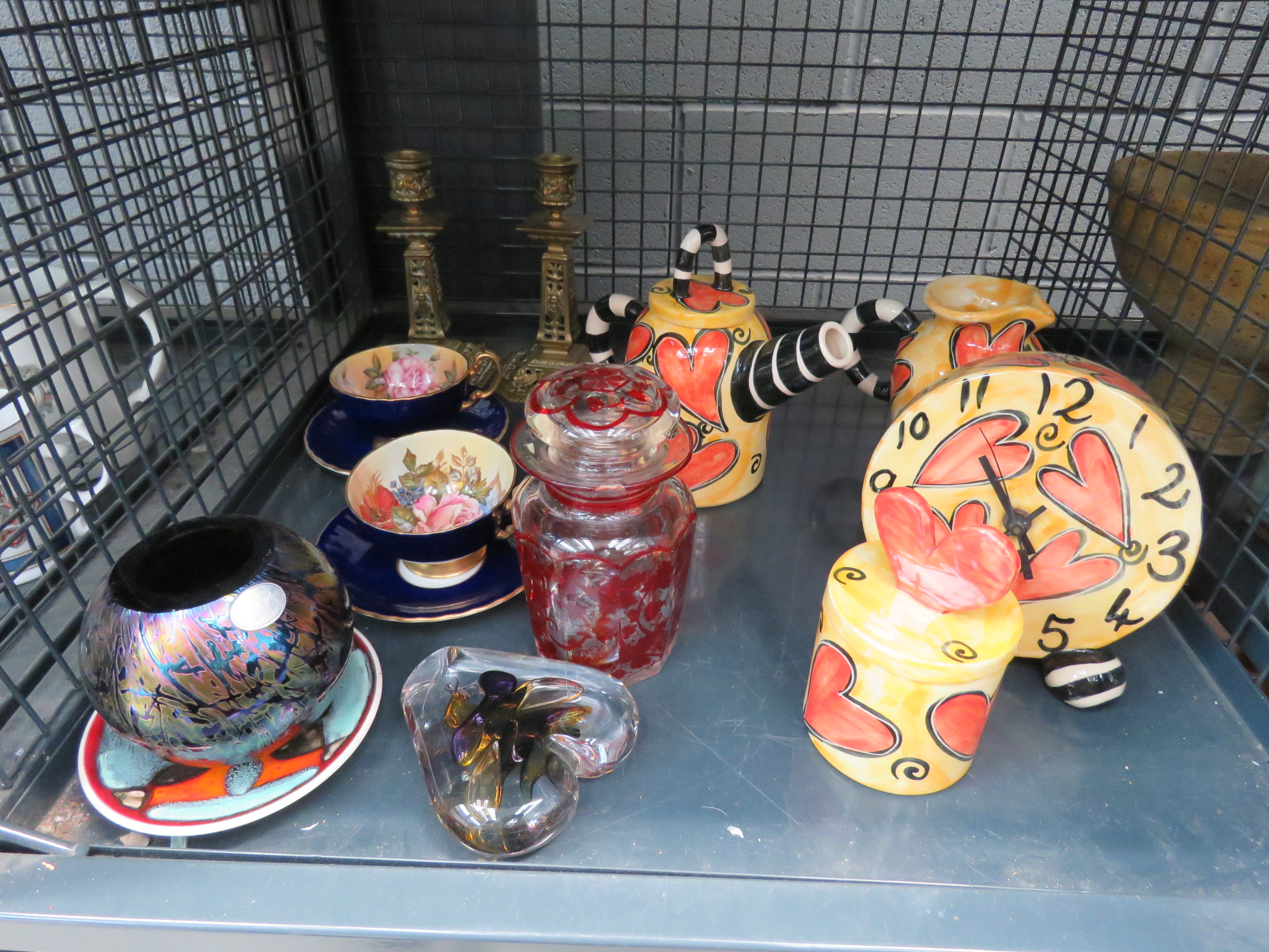 Cage containing a pair of brass candlesticks, paperweight, Poole pottery dish, Royal Brierley pot,