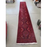 Carpet runner with geometric pattern and maroon background