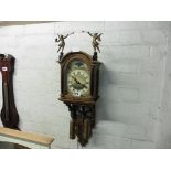 Oak cased weight driven clock with Roman numerals on painted face, moon phase and cherub decoration