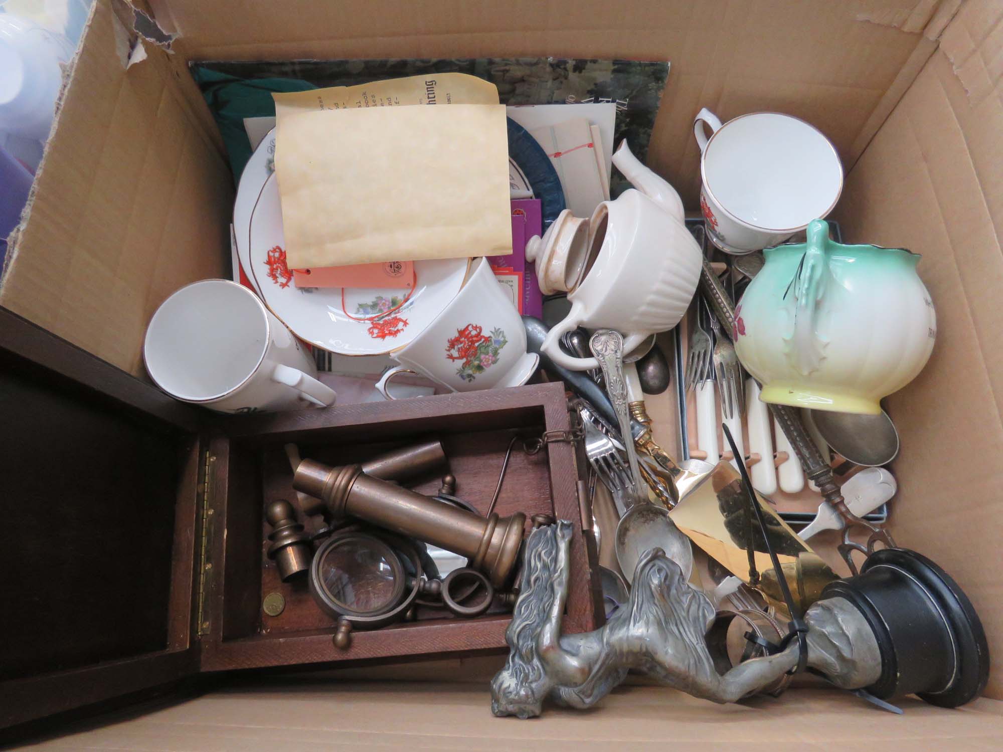 Box containing commemorative ware, boxed microscope, silver plated deco figure, silver napkin
