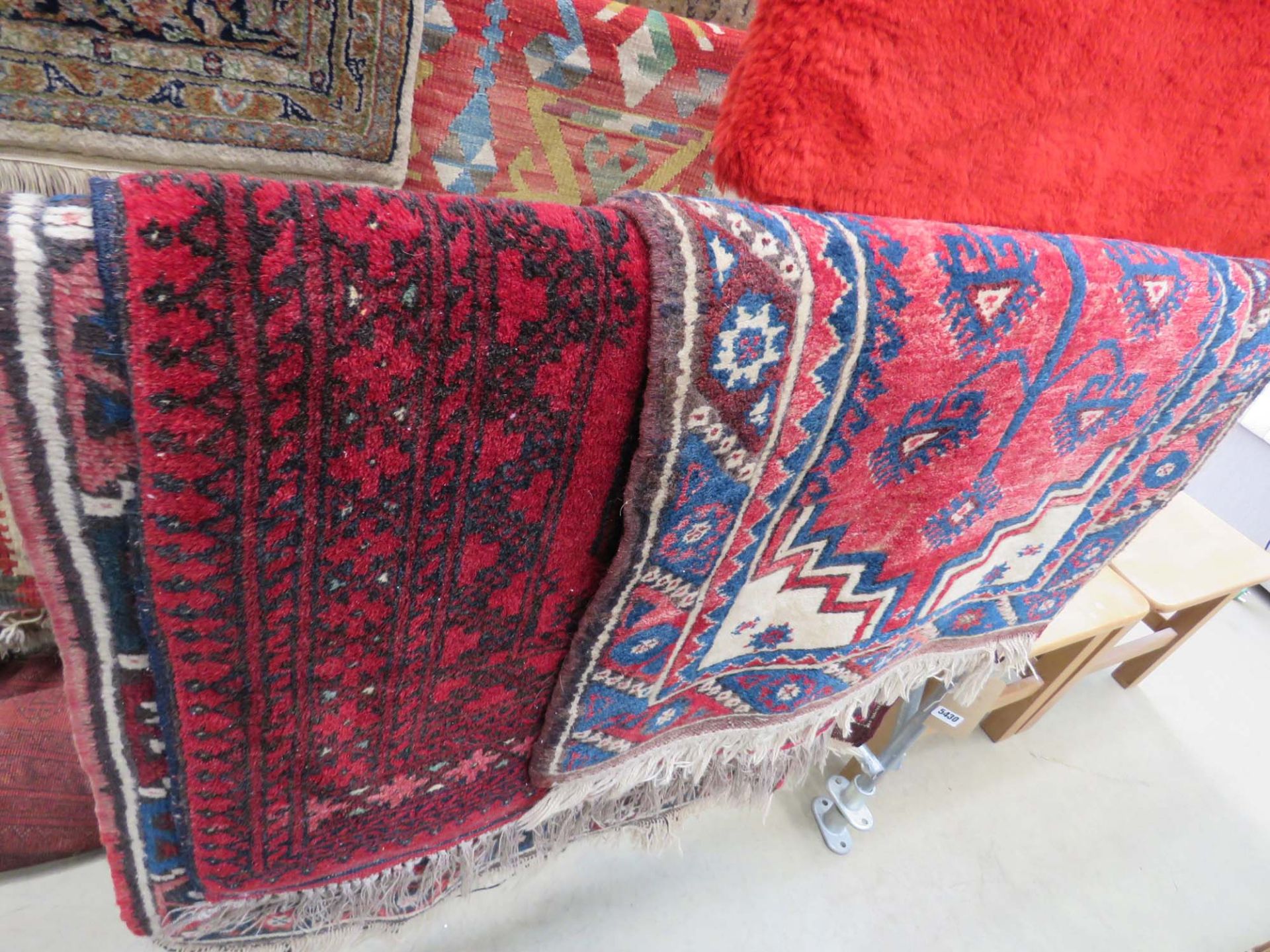 3 red and multi coloured rugs with geometric and floral pattern