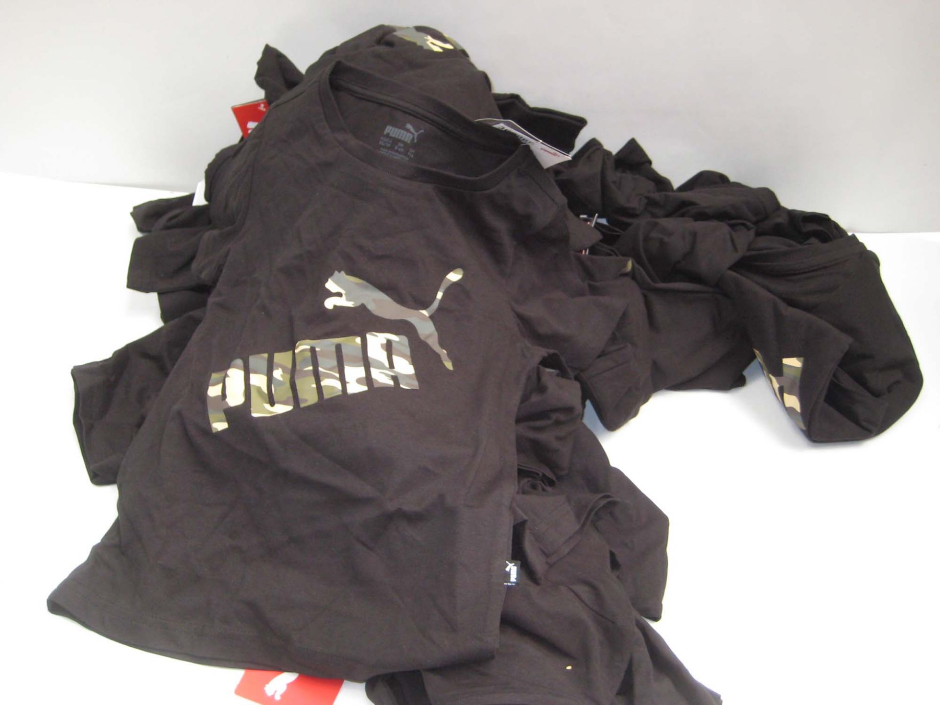 Bag containing childrens Puma t-shirts in white and black with camouflage Puma motif to the front