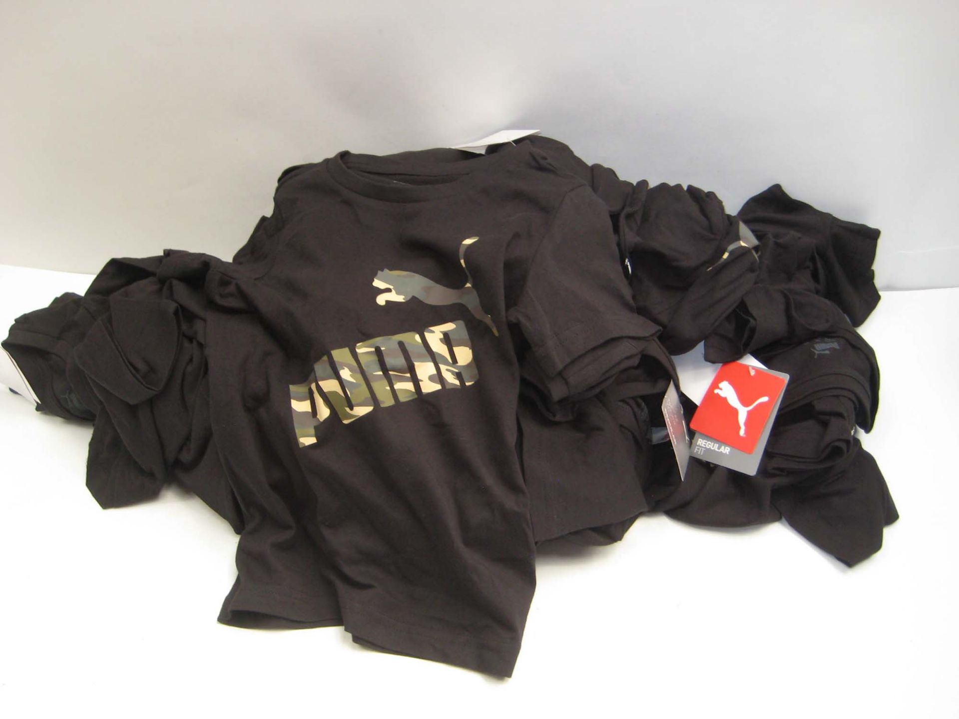 Bag containing childrens Puma t-shirts in white and black with camouflage Puma motif to the front