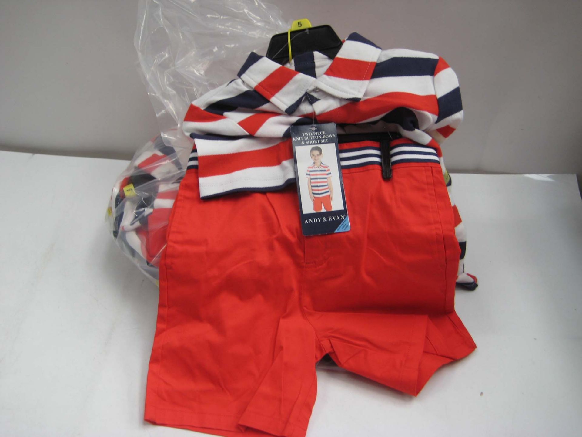 Bag containing 7 childrens shorts and polo shirt combinations by Andrew & Evan