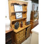 Stripped pine dresser with single cupboard and three drawers with plate rack over