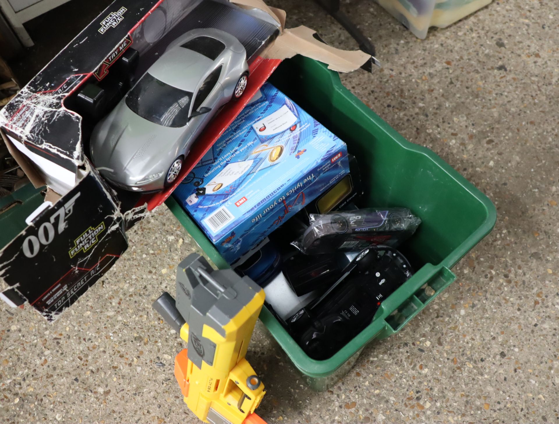 Green crate of various boxed model vehicles and other toys