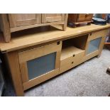 Modern oak low sideboard with two cupboards and central drawers