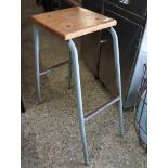 Wooden seated laboratory stool on tubular metal support