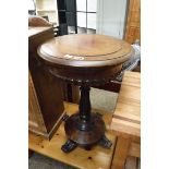 Circular mahogany sewing table on castors, having lift lid and storage wells within