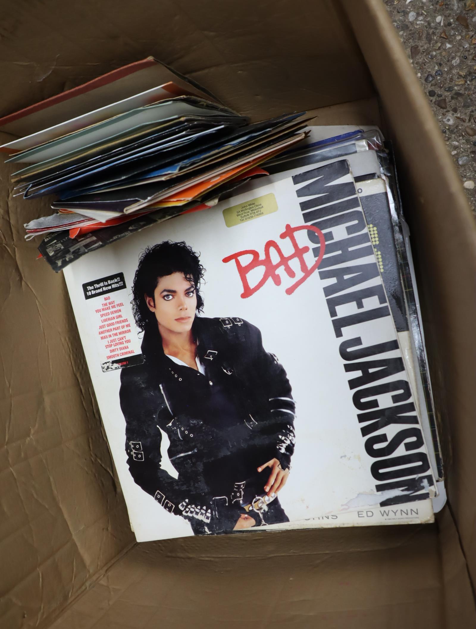 Crate containing vinyl albums and singles incl. Michael Jackson's Bad, Motor Head, etc.