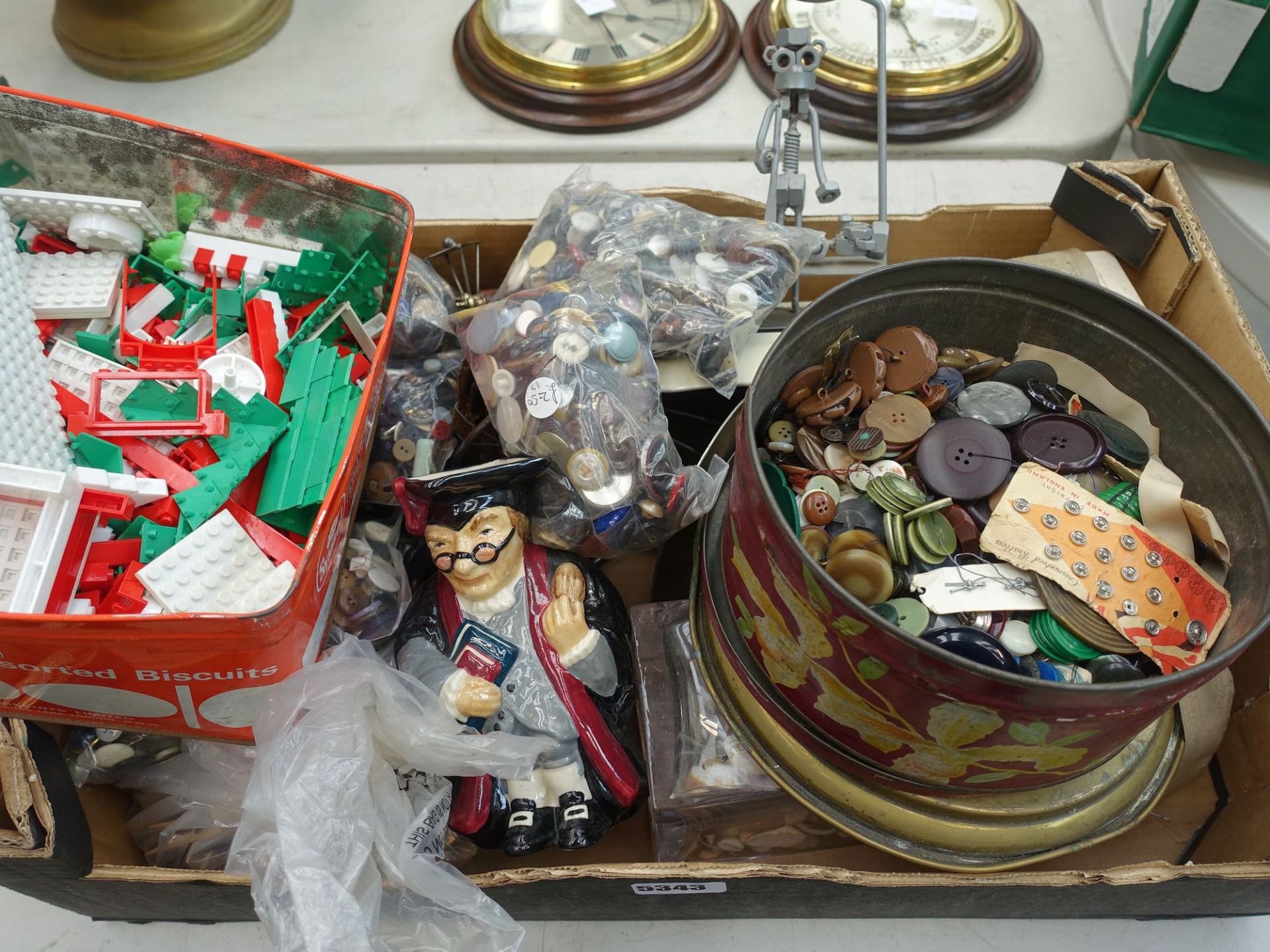 Box containing a quantity of buttons, Lego pieces, character jug and an ornamental metal figure