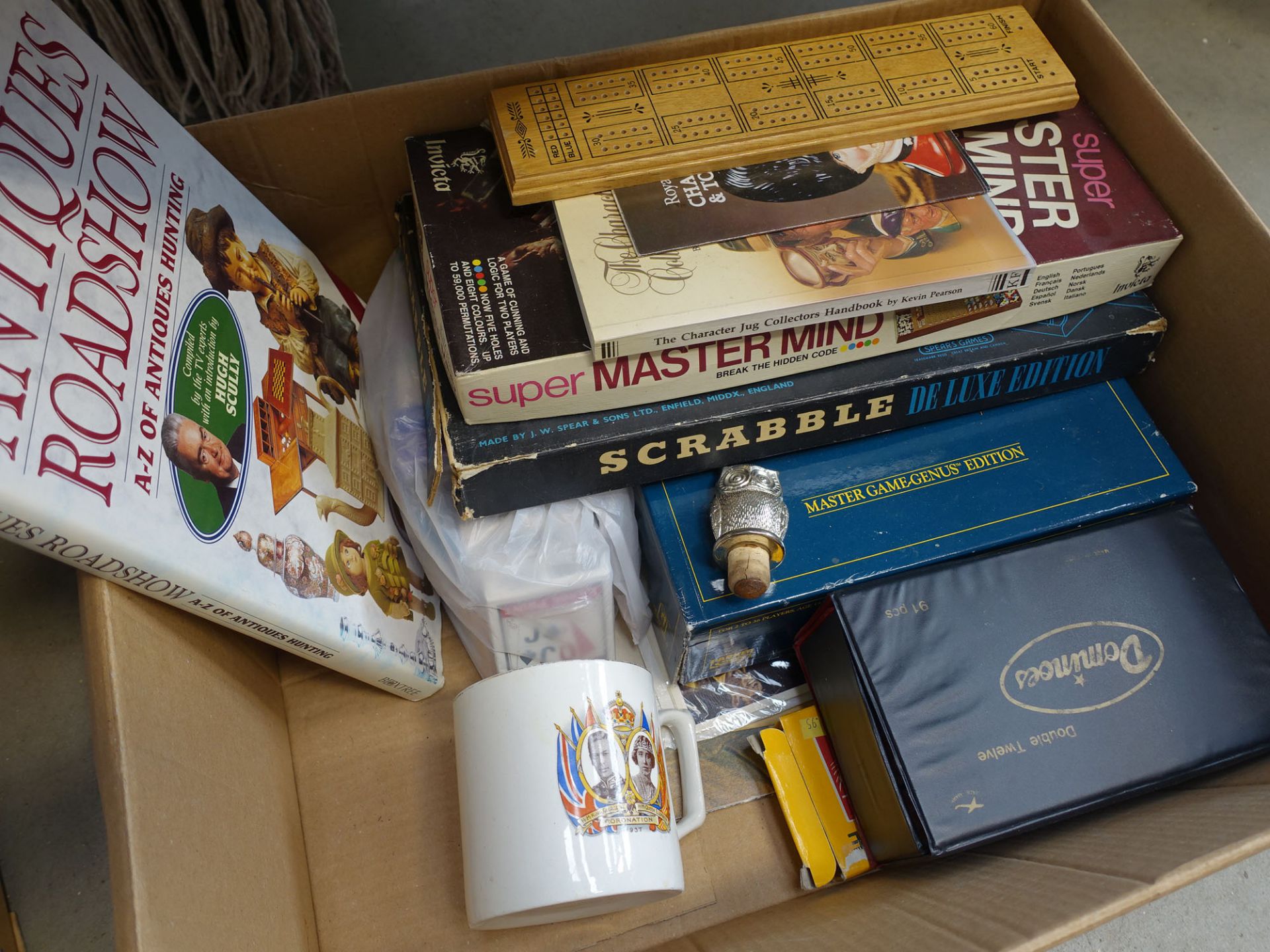 Box containing a commemorative mug, board games and books