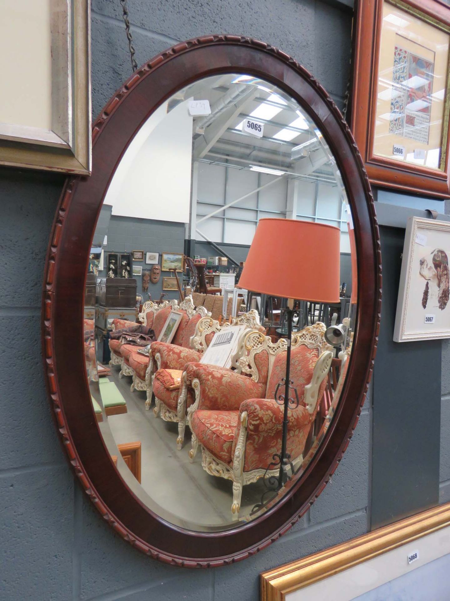 Large oval bevelled mirror in dark wood frame