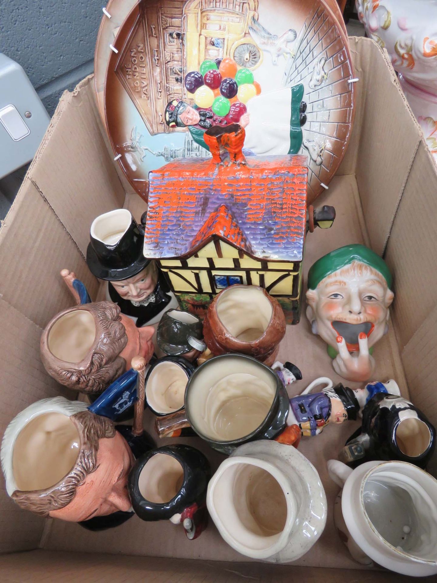 Box containing Toby jugs, cottage biscuit barrel plus a pair of Doulton plates