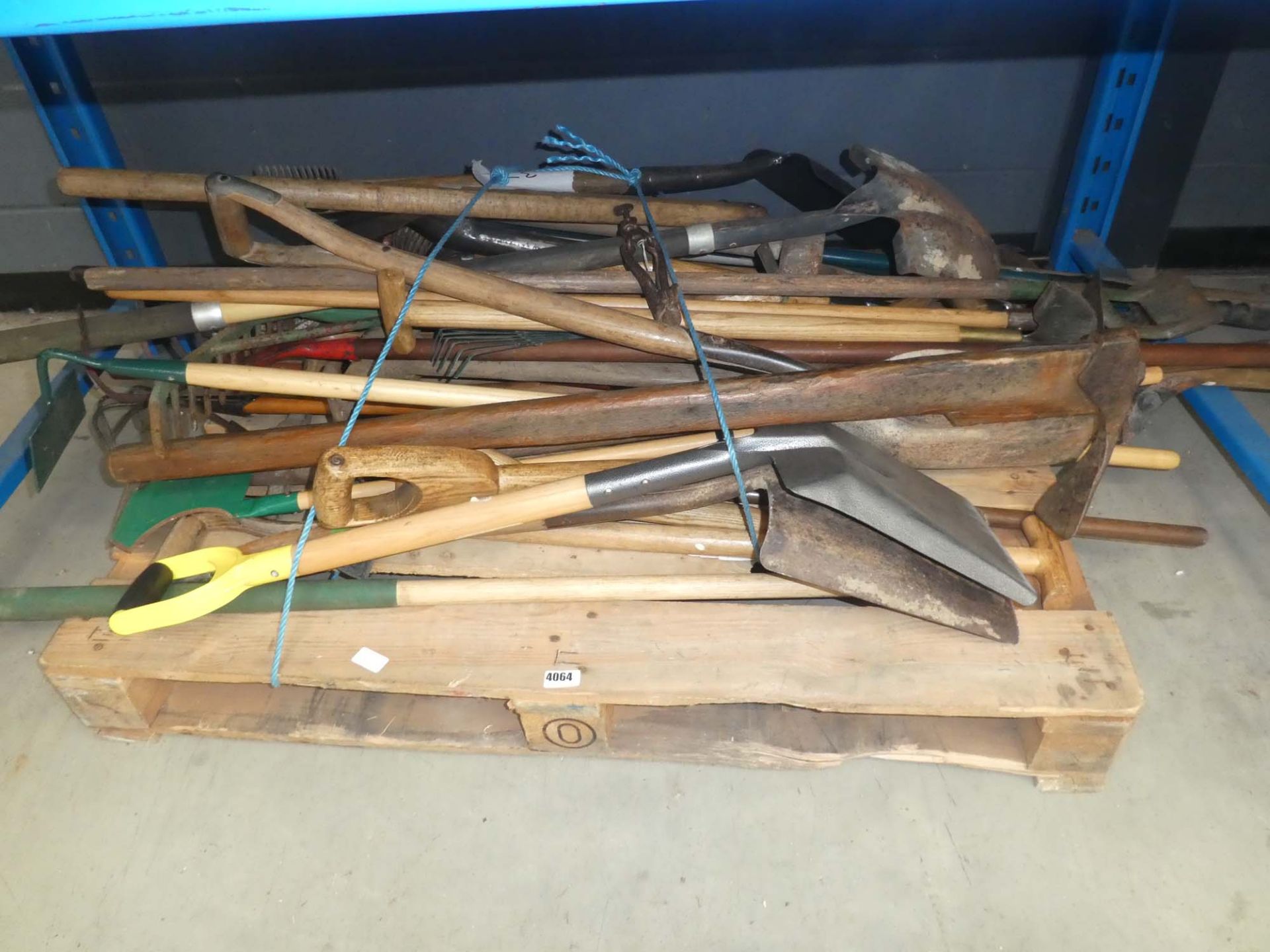 Pallet of assorted garden tools including hose, spades, shovels, rakes, forks, etc