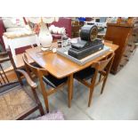 Teak extending dining table by Castle and four matching black rexine seated chairs