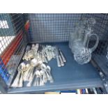 Cage of cutlery and cut glass water jugs