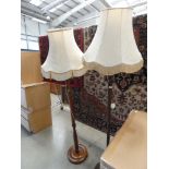 Pair of dark wood standard lamps with cream shades
