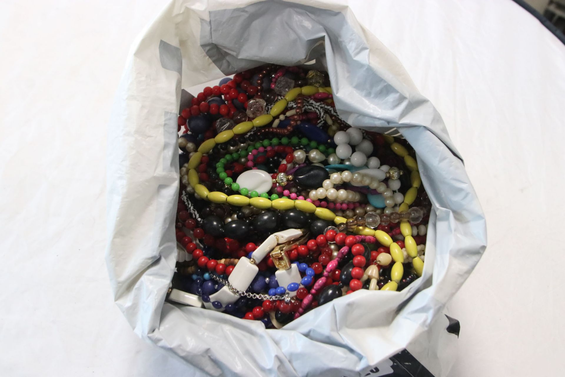 2456 Bag containing various beaded necklaces, costume jewellery, etc.