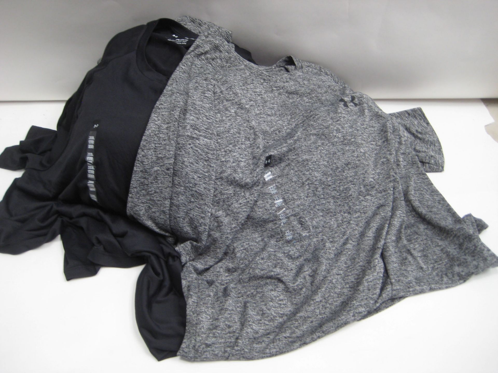 Bag containing approx 18 Under Armour t shirts mainly in black and a few in speckled grey sizes