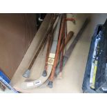 Two hockey sticks, a small group of walking sticks and truncheon