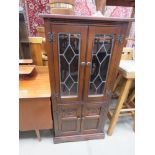 Oak glazed and leaded two door cabinet