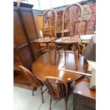 Oak circular dining table with 6 matching wheelback chairs