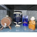 Cage containing sherry barrels, novelty figure, water jug, and Bells whiskey decanter