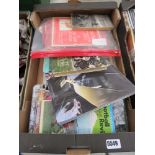 Box containing children's annuals, football programmes and jigsaw puzzles